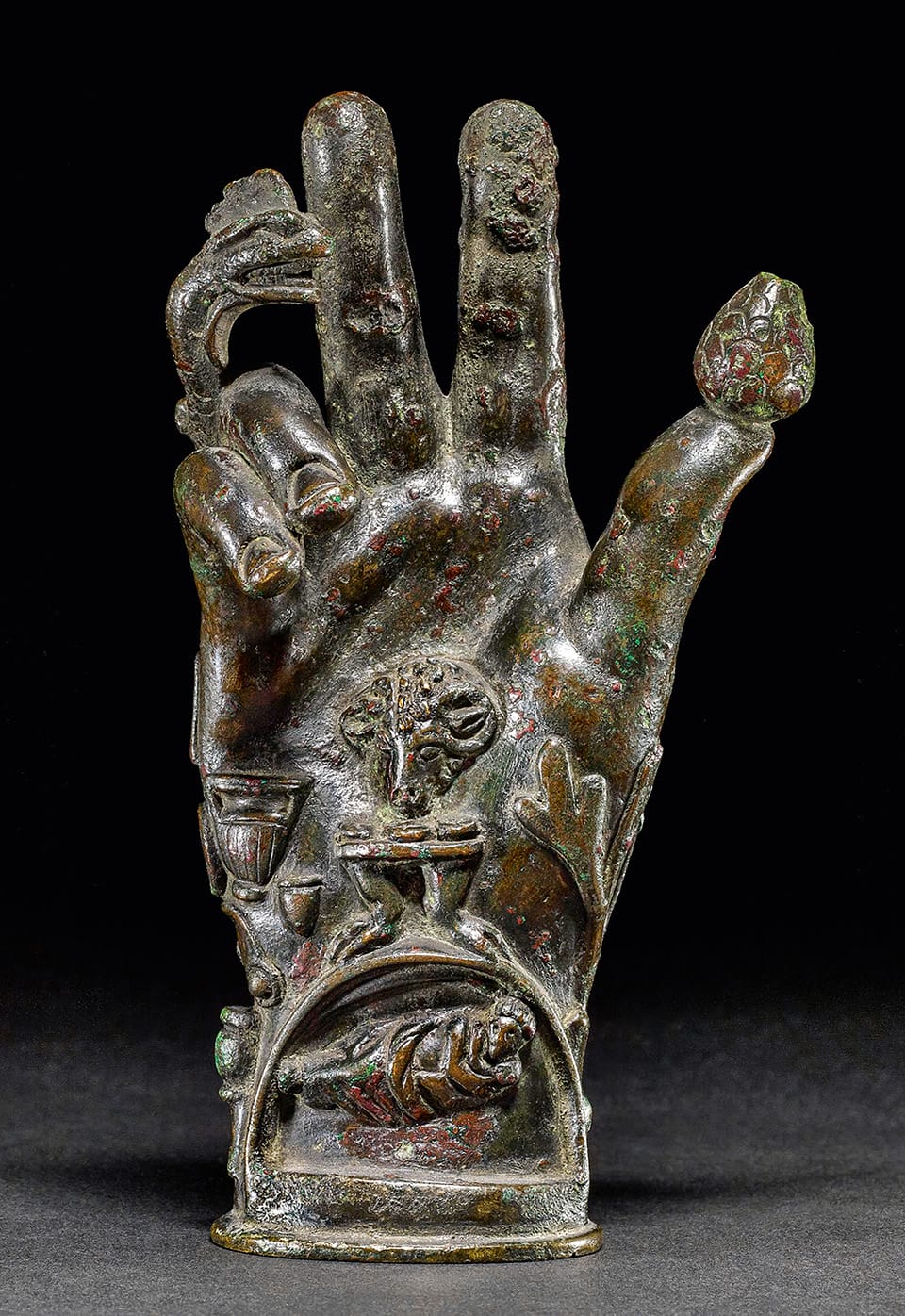 a sculpture of a stone hand with carved, esoteric symbolic elements